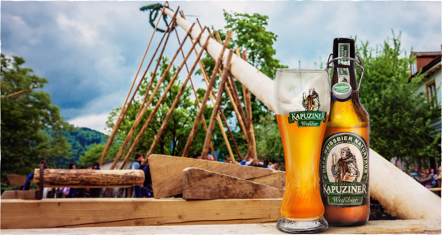 [Translate to Italienisch:] Kapuziner Weißbier vor traditionellem Maibaum-Aufstellen 