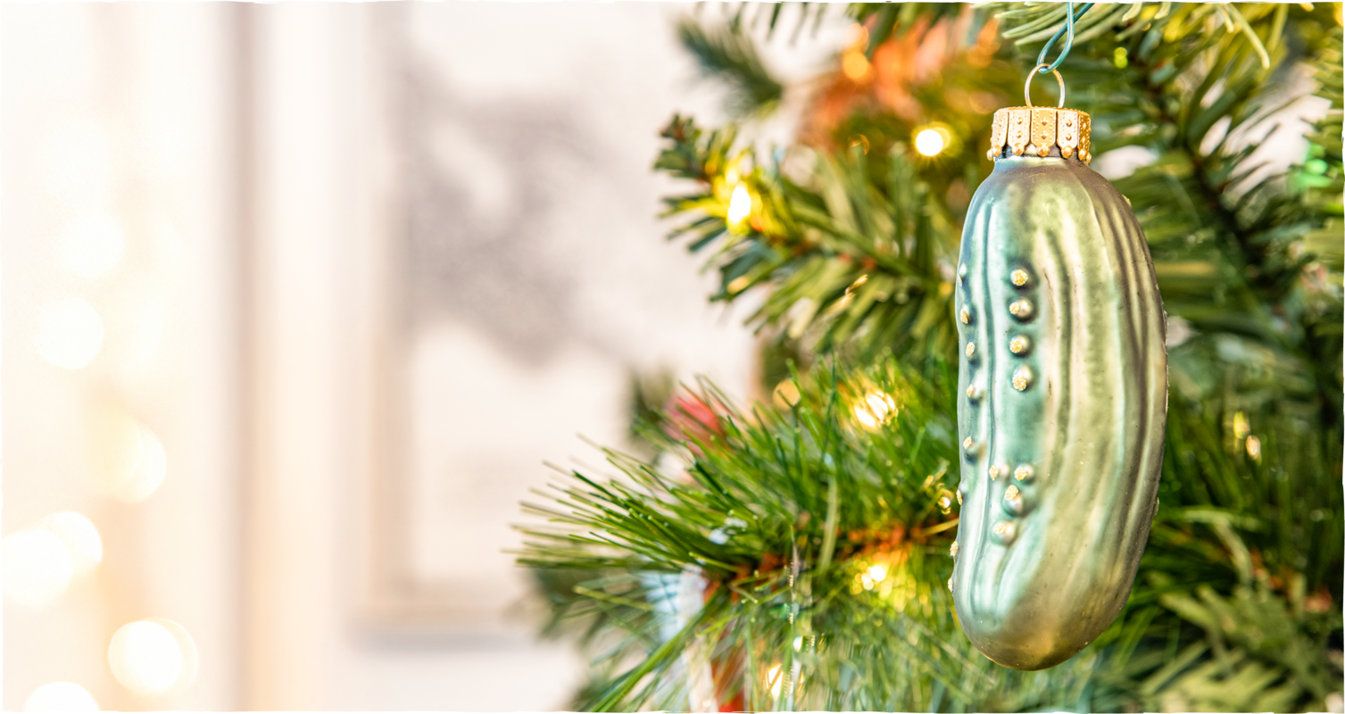 Festlich geschmückter Weihnachtsbaum mit einer Weihnachtskugel in Form einer Gurke